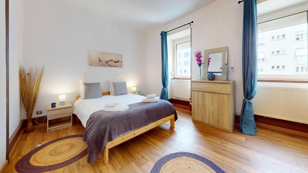 - une chambre avec un lit et une grande fenêtre dans l'établissement Les Cigognes d'Alsace, à Colmar