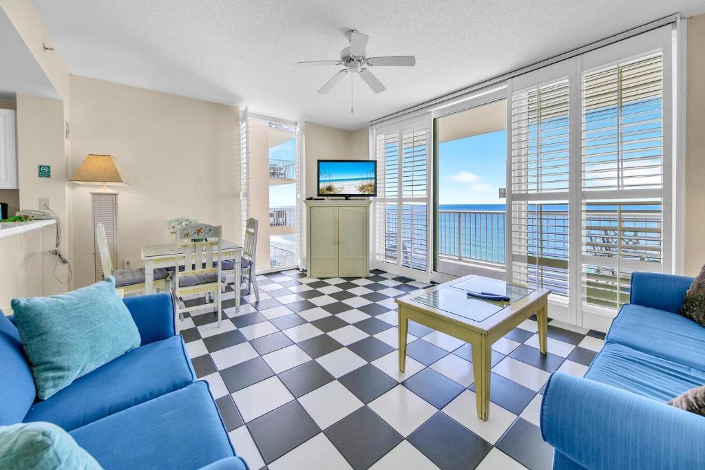 a living room with a blue couch and a table at Majestic Beach Towers 1-1615 in Panama City Beach
