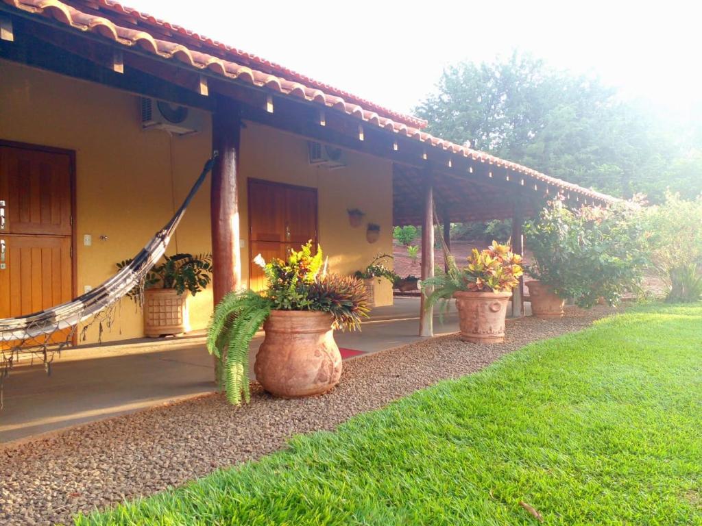 a porch of a house with three potted plants at Pousada Sorocabana in Olímpia