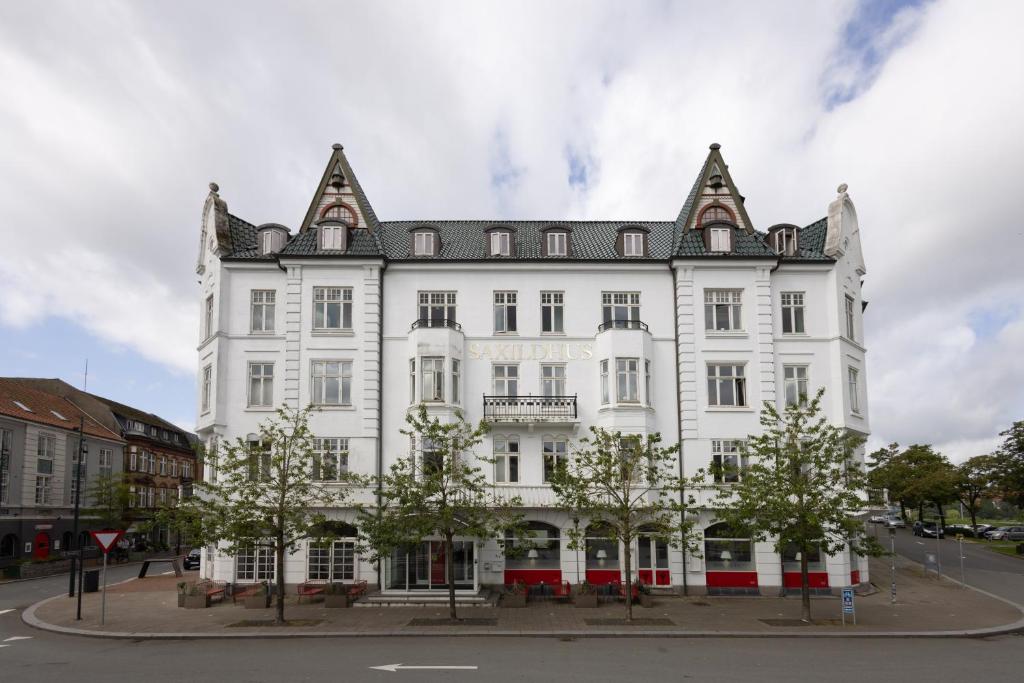 een groot wit gebouw met een puntdak bij Milling Hotel Saxildhus in Kolding