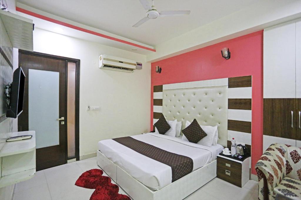sypialnia z dużym łóżkiem i czerwoną ścianą w obiekcie Hotel Star Inn - Delhi Airport, Mahipalpur, Aerocity w Nowym Delhi