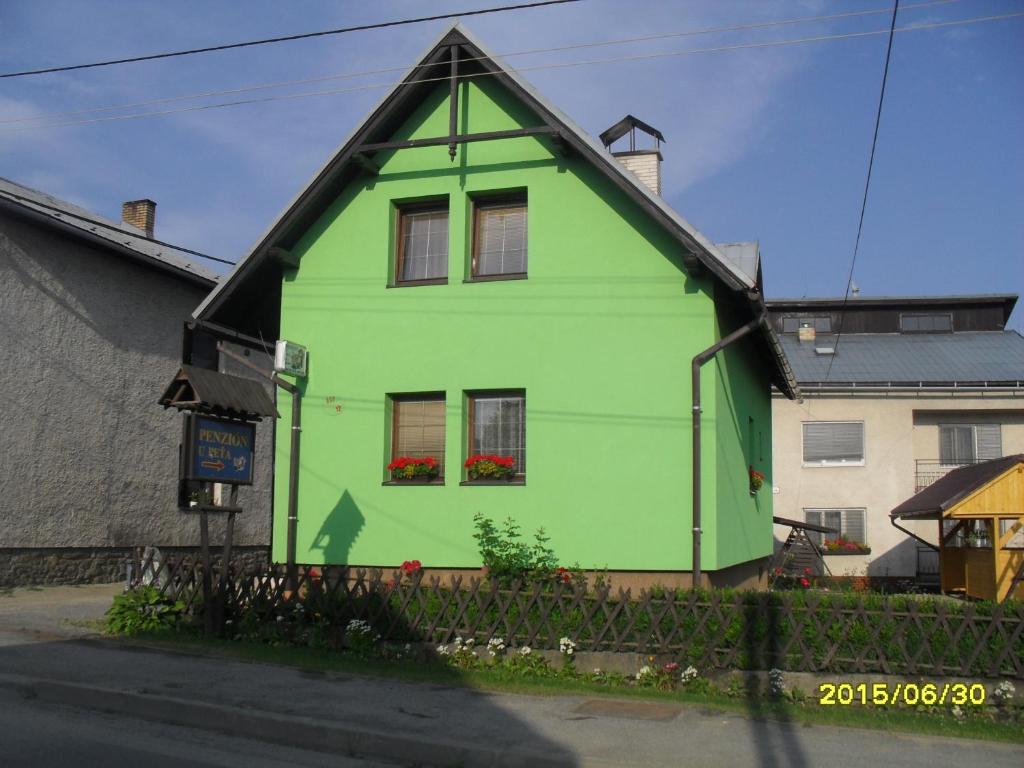 a green house with a black roof at Penzión u Peťa in Hruštín