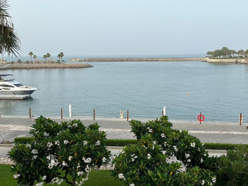 Ein Boot ist in einem großen Wasserkörper angedockt. in der Unterkunft Magical Marina View Sifah Resort in As Sīfah