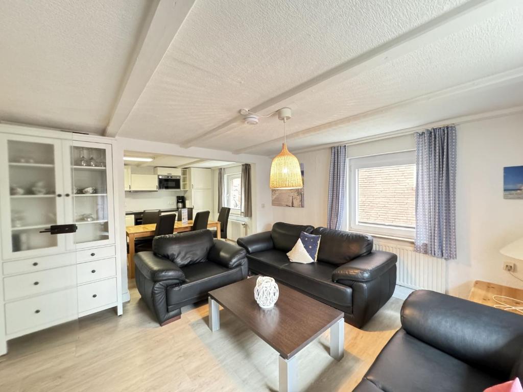 a living room with black leather furniture and a table at Führs in Borkum
