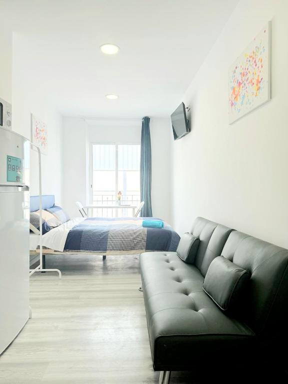ein Wohnzimmer mit einem Sofa und einem Bett in der Unterkunft Apartamentos Aeropuerto Valencia in Manises