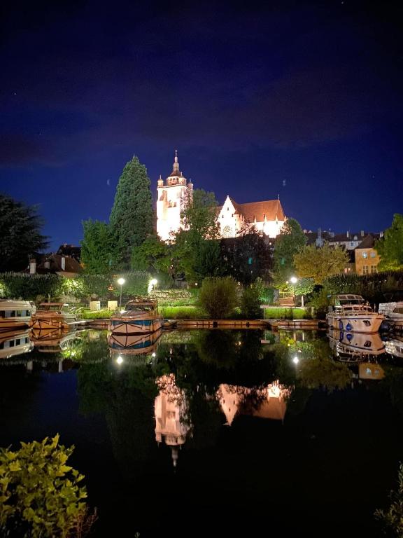 un bâtiment avec une réflexion dans l'eau la nuit dans l'établissement Domaine de Val combe, à Dole