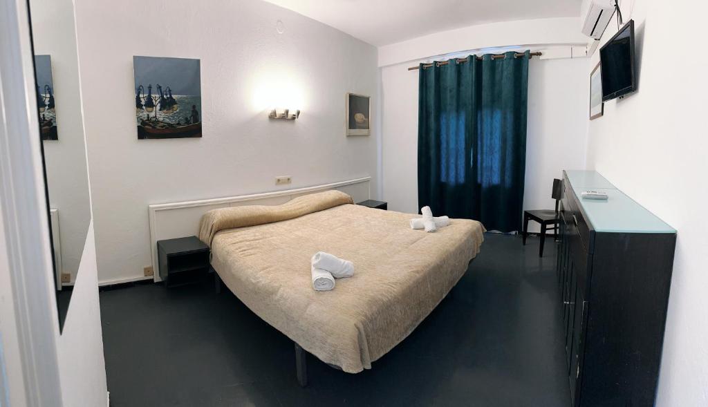 1 dormitorio con 1 cama con 2 toallas en New Roser en L'Escala