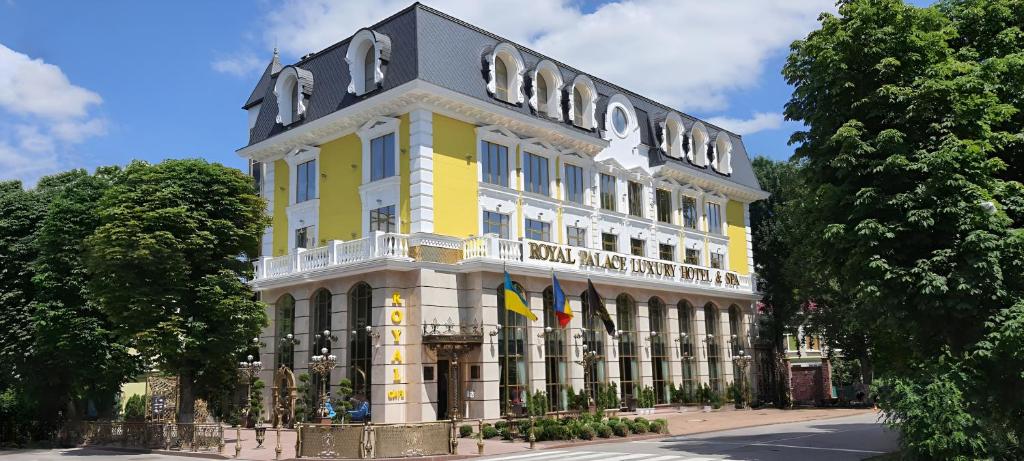 un edificio blanco y amarillo con un letrero. en Royal Palace Luxury Hotel and SPA en Khmelʼnytsʼkyy