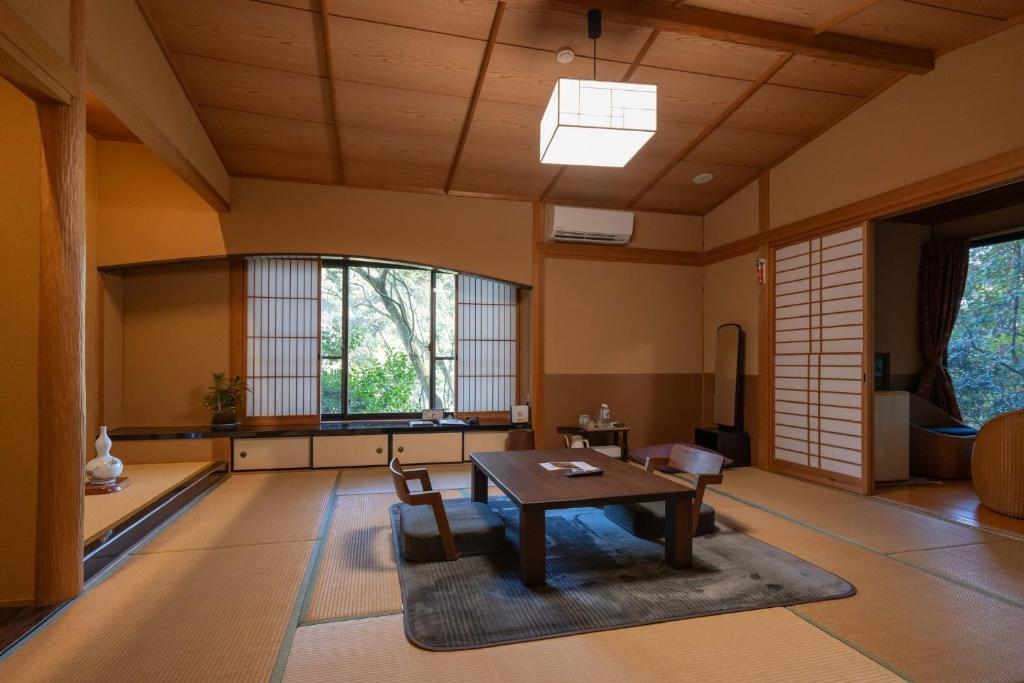 a living room with a table and chairs in it at Kirishima Seiryuso in Kirishima