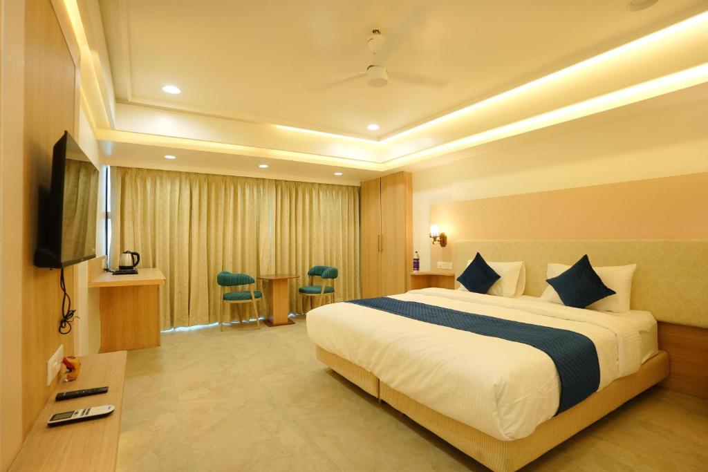 a hotel room with a large bed and a table at Hotel 6 Seasons, Koregoan Park, Pune in Pune