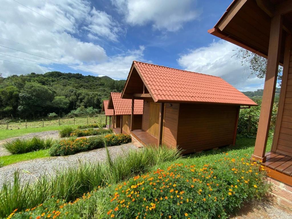 a couple of small buildings in a field of flowers at Cabanas Encantos da Natureza in Gramado