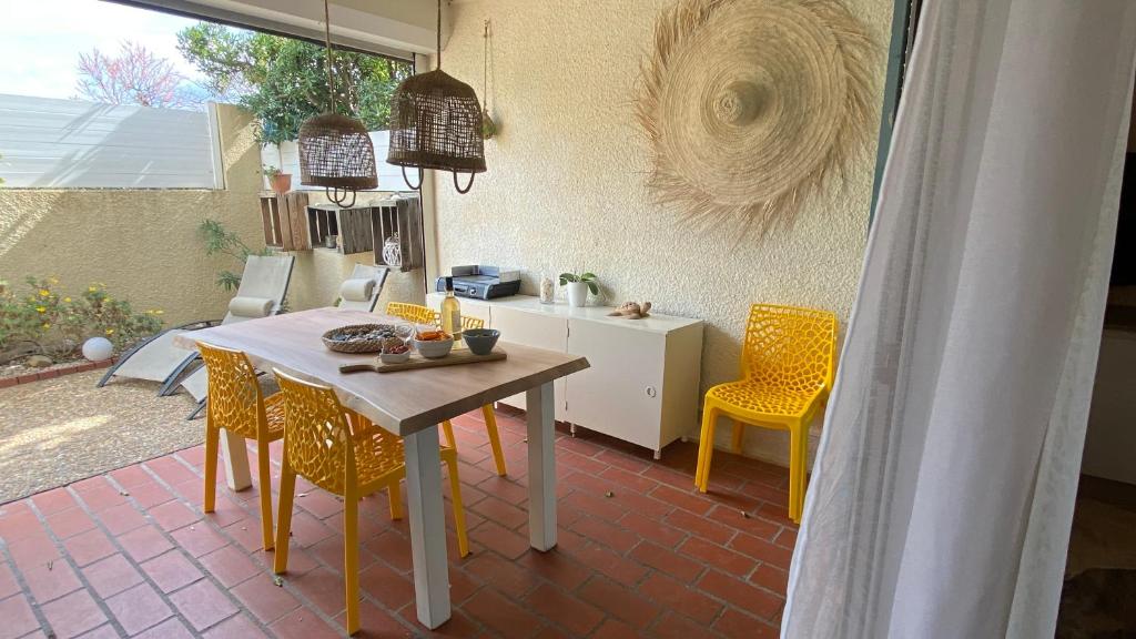 ポール・ルカートにあるLE FARNIENTE FRONT DE MER clim wifi jardin parkingのキッチン(テーブル、黄色い椅子付)