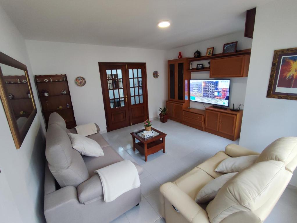 a living room with two couches and a television at Amplio Apartamento con terraza a 150 m playa in Porto do Son