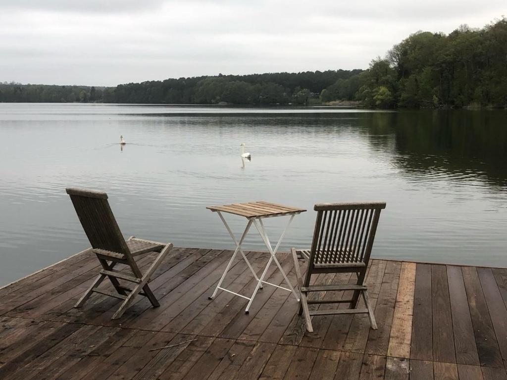 two chairs and a table on a dock with a lake at Forsthaus am See Lychen in Lychen