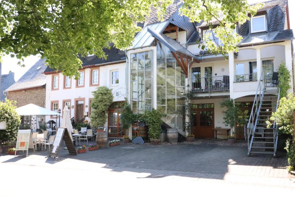 ein Haus mit einer Glasfassade und einer Terrasse in der Unterkunft Ferienweingut & Gutsrestaurant Becker in Burgen