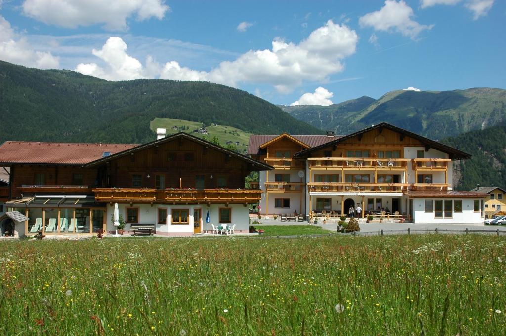 un gruppo di edifici con montagne sullo sfondo di Alpenhof Wolayersee a Birnbaum