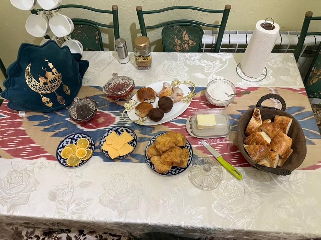 een tafel met borden met voedsel op een tafel bij Hotel ISMOIL SAMONI in Bukhara