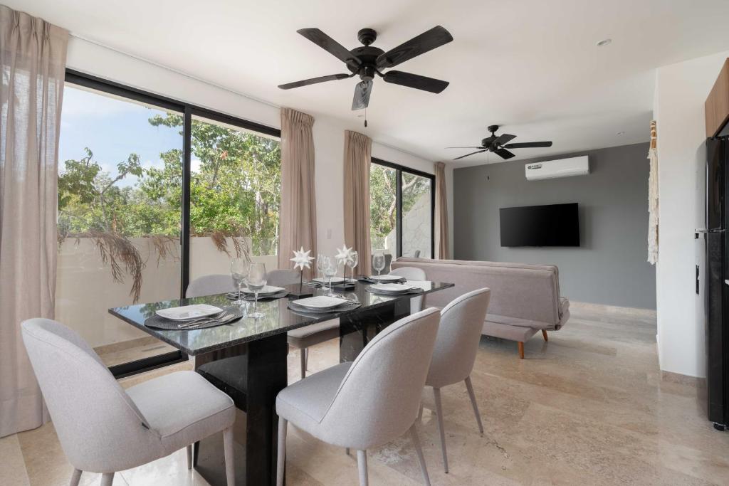 a dining room with a table with chairs and a ceiling fan at 2BD with Rooftop Pool near Beach in Tulum