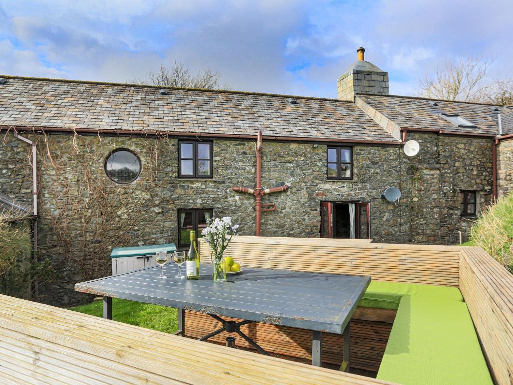 an outdoor deck with a table and a building at Higher Rowes Farm in Marytavy
