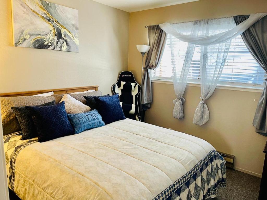 a bedroom with a bed with blue pillows and a window at Wonderful Private Queen Bedroom in Santa Clara