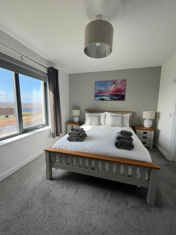 a bedroom with a bed and a large window at Sgothan Dearg in Portree