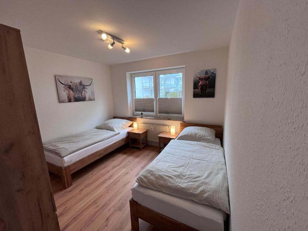 a bedroom with two beds and a window at Familie-und-Meer-2-Badezimmer-3-Schlafzimmer-Strandnah-im-Ostseebad-Baabe-Baabe in Baabe