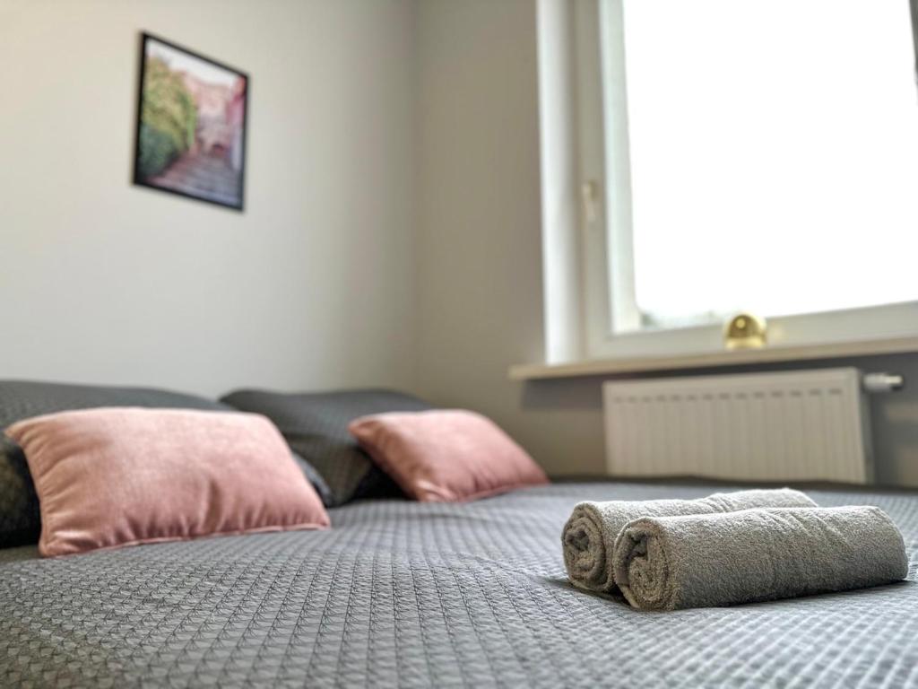 a bed with two towels on top of it at MMRent Florence Room in Gdańsk