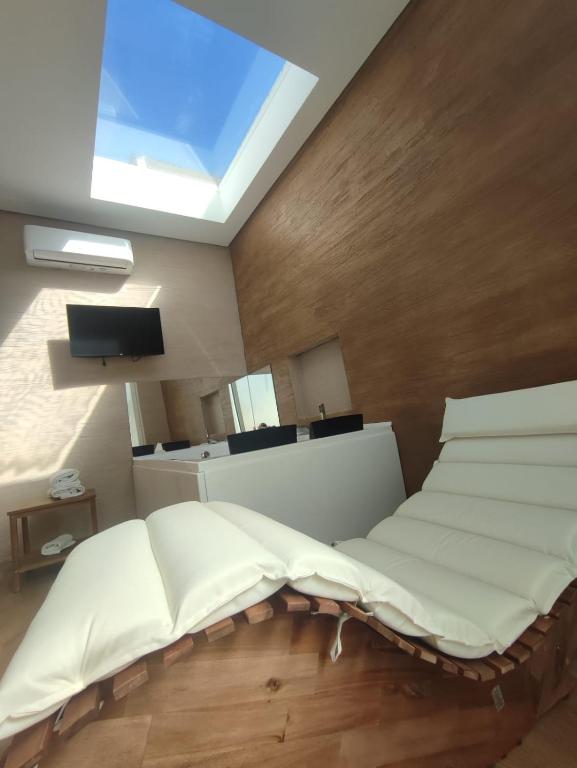 a bedroom with a white bed and a skylight at Dimora Fajano in Fasano