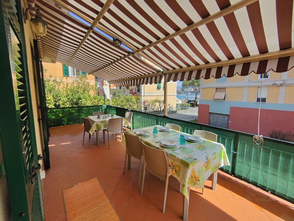 a patio with tables and chairs on a balcony at Giulio's terraces in the bay in Le Grazie