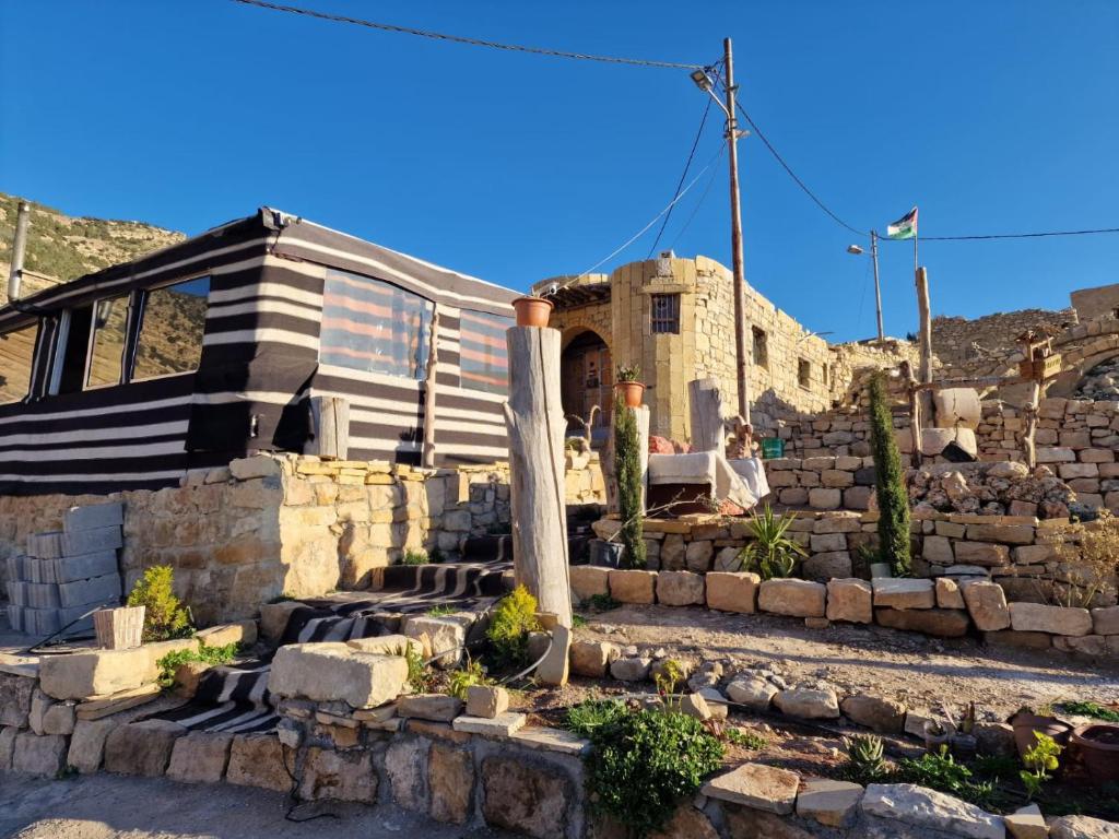 a house with a stone wall and stairs in front of it at My Grandfather's House in Dana