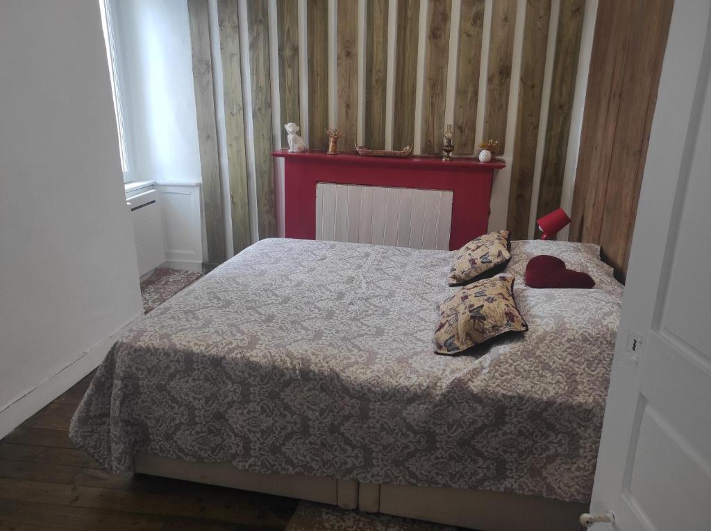 ein Schlafzimmer mit einem Bett mit zwei Kissen darauf in der Unterkunft Enchanté ! Chambres d'hôtes Brocéliande in Mauron