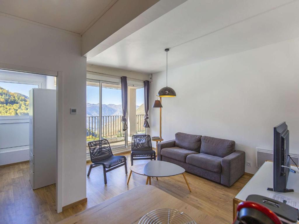 un salon avec un canapé et une table dans l'établissement Appartement rénové 8 pers, terrasse, ski, wifi - FR-1-400-106, à Eaux-Bonnes