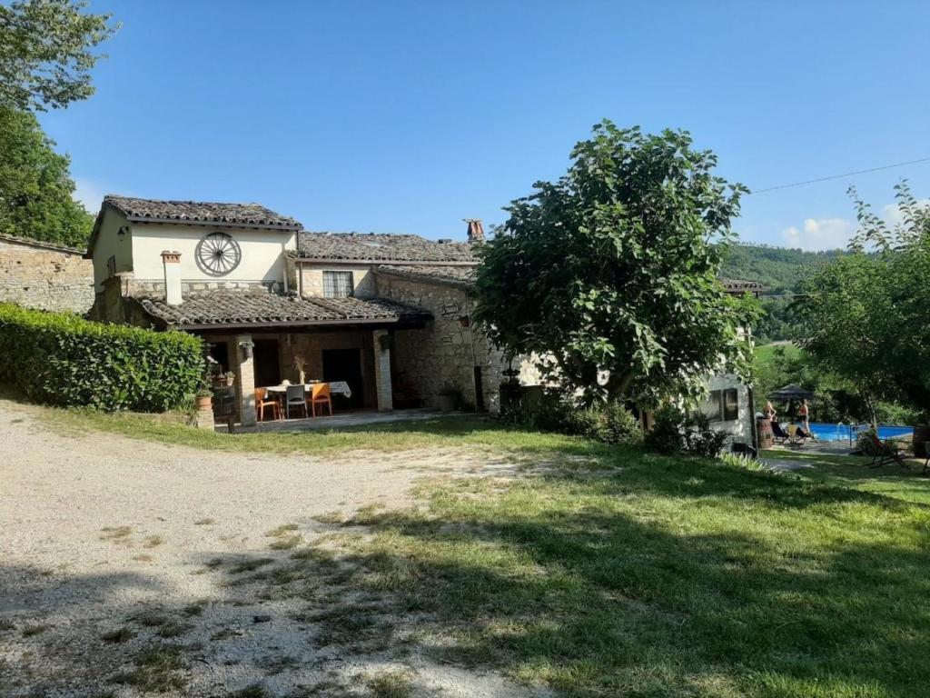 Una casa con un reloj al costado. en Tolles Ferienhaus in Urbino mit Grill, Garten und Terrasse, en Urbino