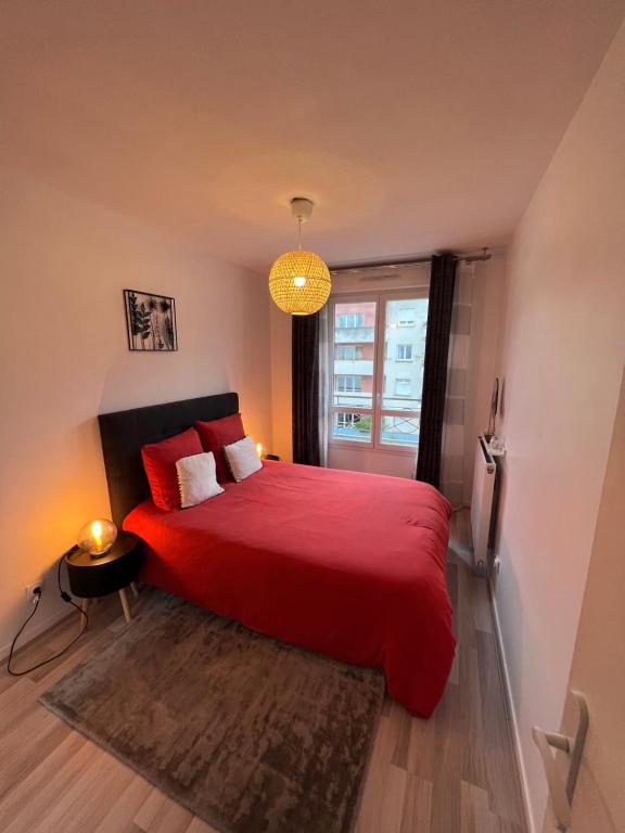 - une chambre avec un lit rouge et une fenêtre dans l'établissement Appt à 10 min de Paris, 15 min a pied du SDF, à Saint-Denis