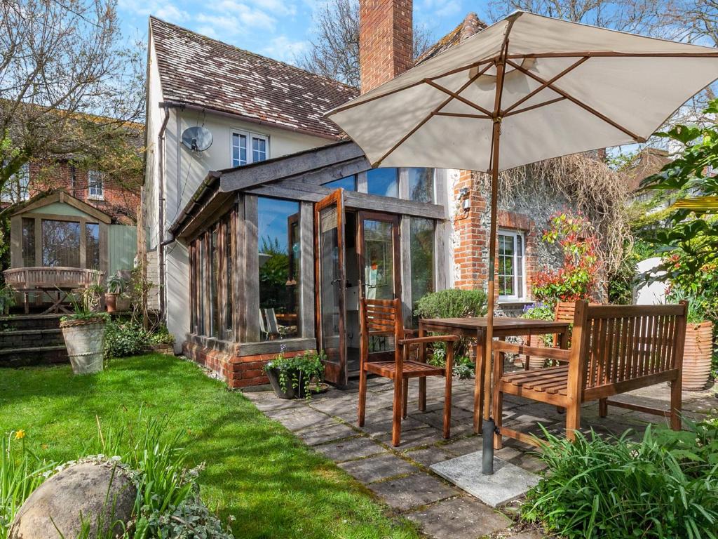 a patio with a table and an umbrella at Pensway in Burpham