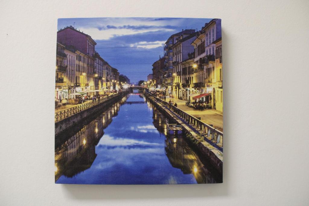 uma pintura de um canal numa cidade em Travelounge Milano San Siro em Milão