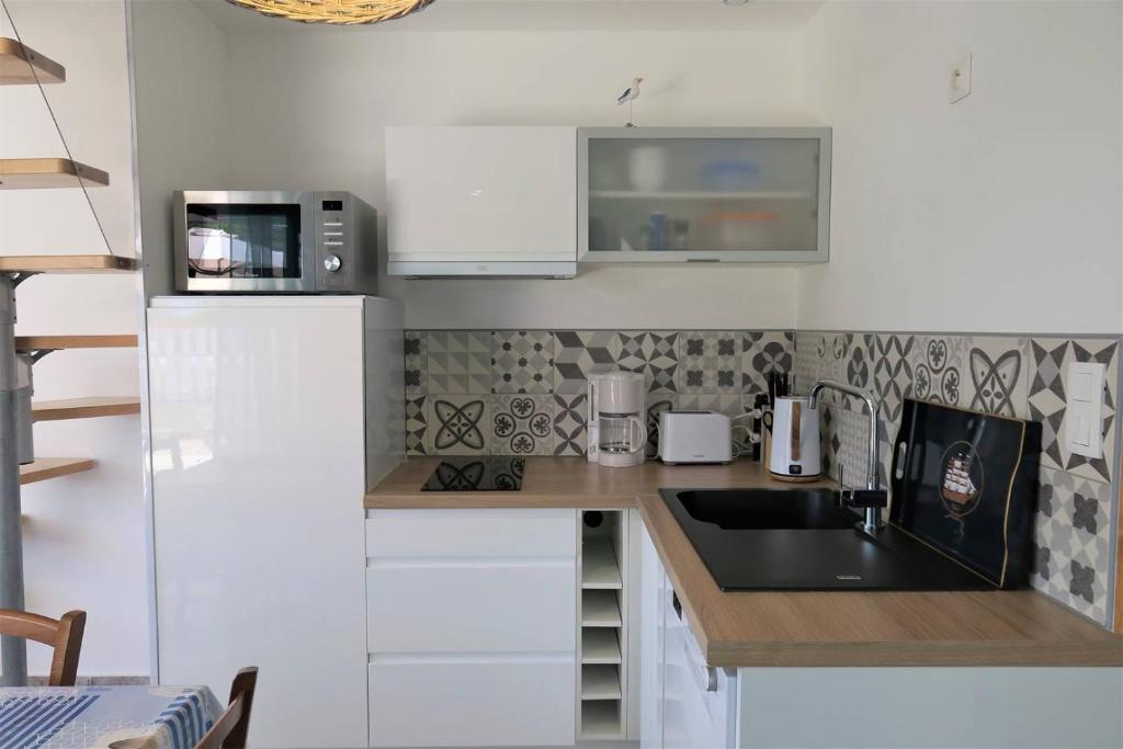 Kuchyňa alebo kuchynka v ubytovaní Maison rénovée avec Wifi, jardin, à 450m du centre de PERROS-GUIREC - Réf 924