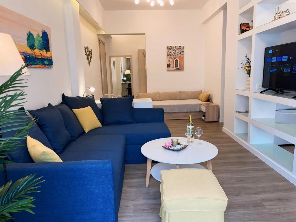 a living room with a blue couch and a table at Dante Apartment in Athens