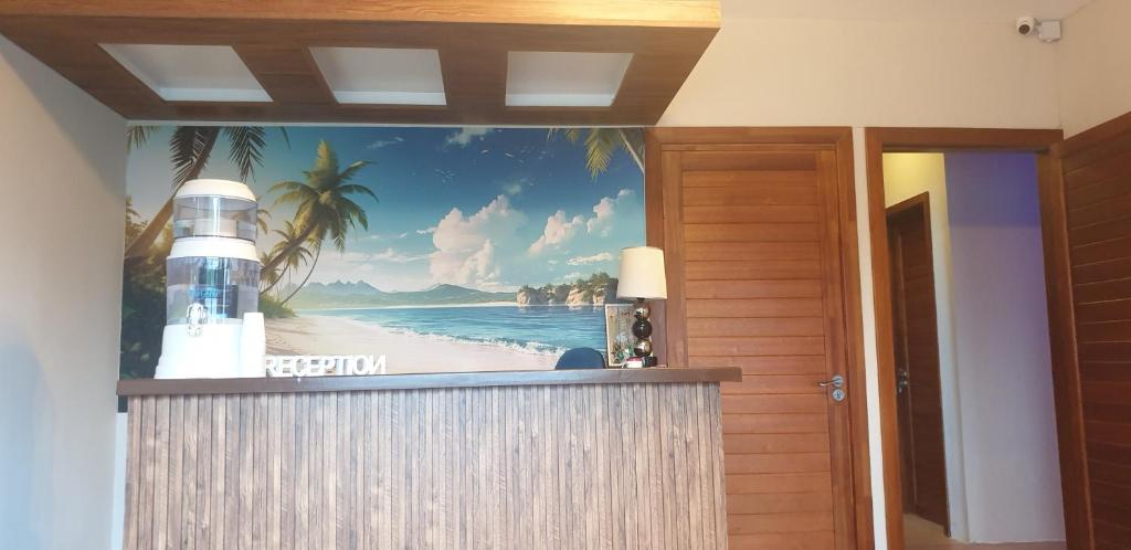a mural of a beach with a lighthouse on the wall at Royal Residency in Plaine Magnien