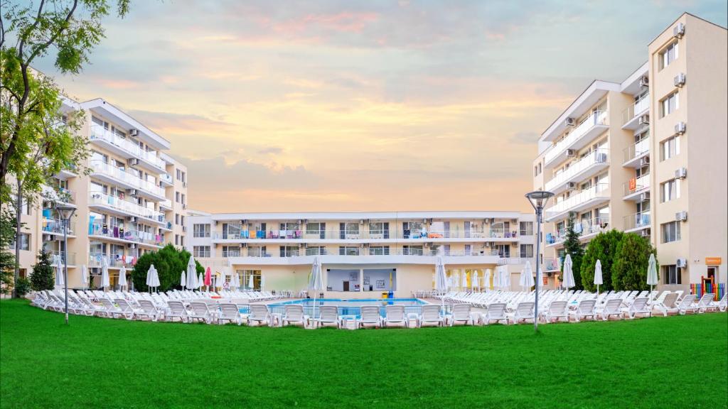 una vista exterior de un hotel con sillas y césped en Hotel Garden Nevis - All Inclusive, en Sunny Beach