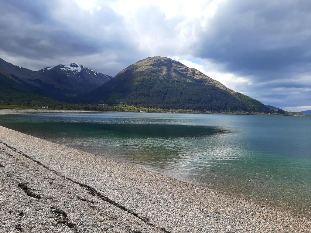 a mountain sitting next to a body of water at View of the Mountain in North Ballachulish