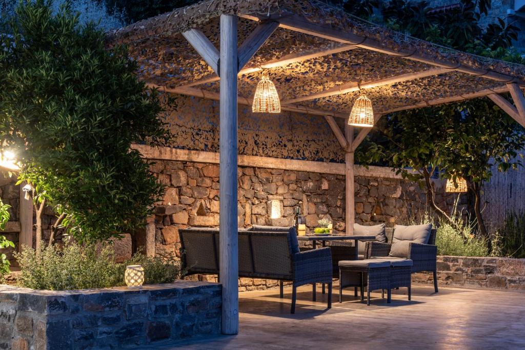 a patio with a table and chairs under a pergola at VATHI SPIROS VILLAS in Agios Nikolaos