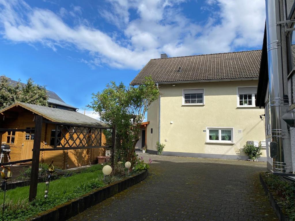 a house with a pavilion next to a driveway at FeWo Sonnenlay - Apartments an der Mosel in Brauneberg