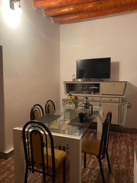 a dining room with a table with chairs and a tv at Néctar in Tinogasta