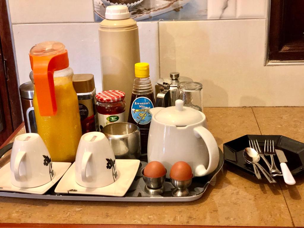 a tray with a tea kettle and eggs on a counter at Sarf travelers motel in Kasese