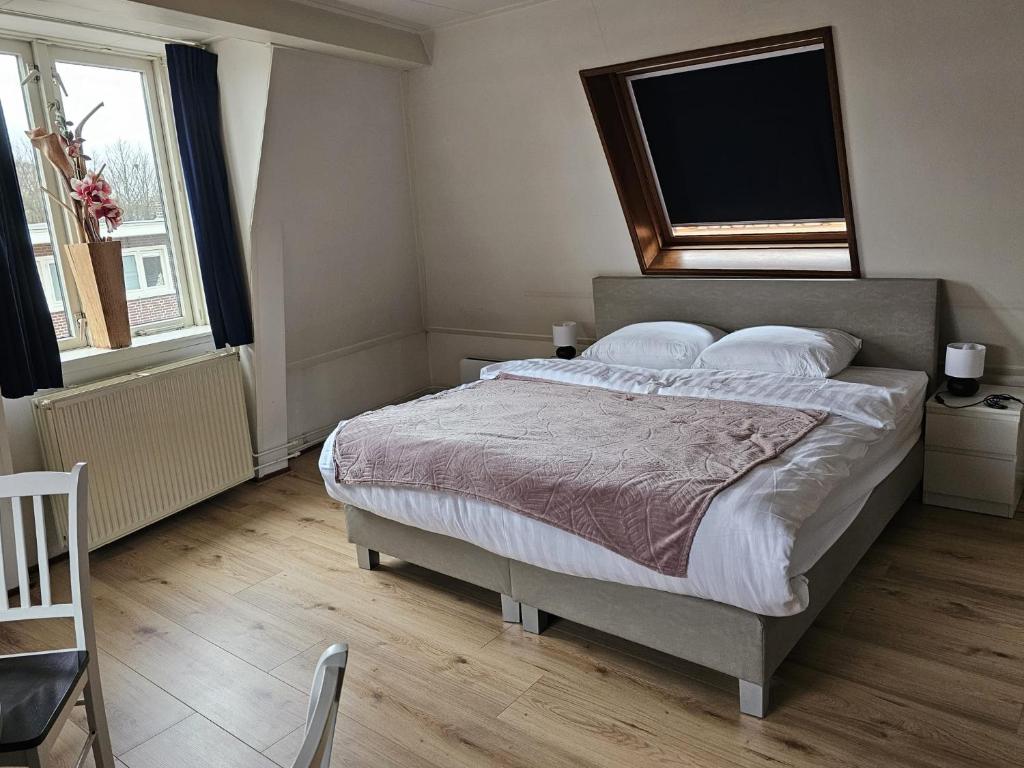 een slaapkamer met een groot bed en een groot raam bij City Centre Suite in Hoorn