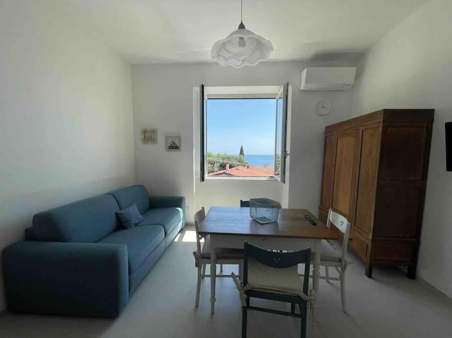 ein Wohnzimmer mit einem blauen Sofa und einem Tisch in der Unterkunft Casa Dalidà in Tellaro