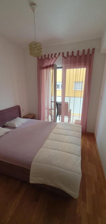 - une chambre avec un grand lit et une fenêtre dans l'établissement Odmor u Podgorici., à Podgorica