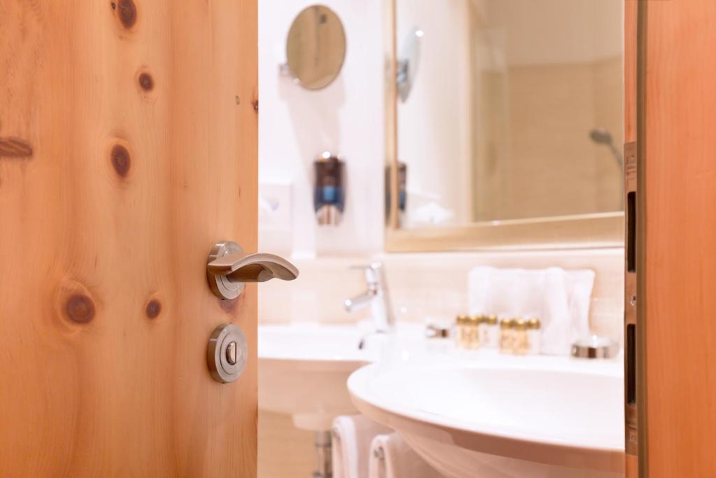 a bathroom with a sink and a toilet at Chasa Castello relax & spa in Samnaun