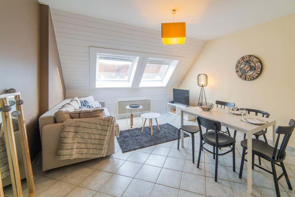 een woonkamer met een bank en een tafel en een eetkamer bij Le central in Mulhouse